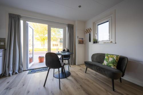 una sala de estar con un sofá y una mesa en Zonnelande - comfort studio, en Zoutelande