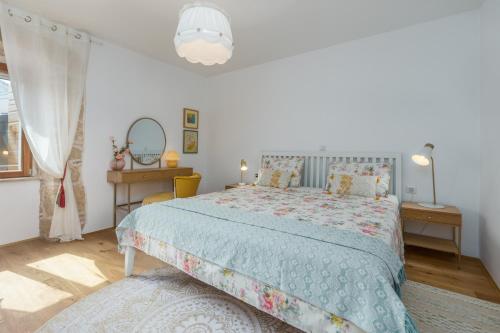 a bedroom with a bed with a blue comforter at Casa Jagoda in Višnjan