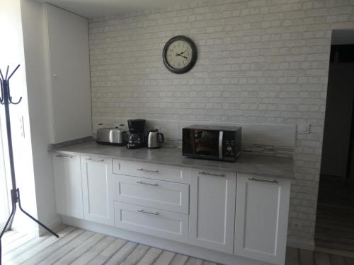 une cuisine avec un comptoir avec une horloge murale dans l'établissement Gîte de la forge, à Trélévern