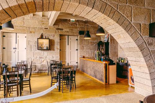 a restaurant with a stone wall and tables and chairs at Casa das Mourôas in Mondim de Basto