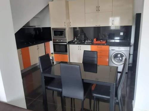 a kitchen with a table and chairs and a stove at Mar House Apartments in Praia