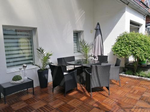 une terrasse avec une table, des chaises et un parasol dans l'établissement Ferienhaus Resit 1, à Steinhude