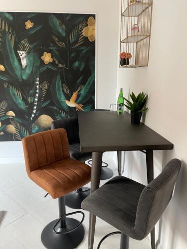 a table and two chairs in a room with a painting at Nova Apartamenty Rewa in Rewa