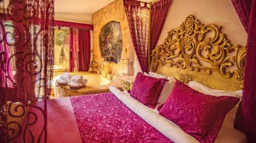 a bedroom with a large bed with purple pillows at Lethe Exclusive Hotel in Ağva