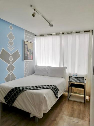 a bedroom with a large bed and a blue wall at Kubo Hotel & Business Center in San Miguel de Allende