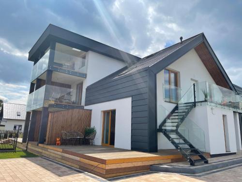 a modern house with a black roof at Nova Apartamenty Rewa in Rewa