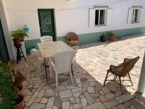 a patio with a table and chairs on a stone floor at Casa Fagundes com 3 Quartos in Sagres