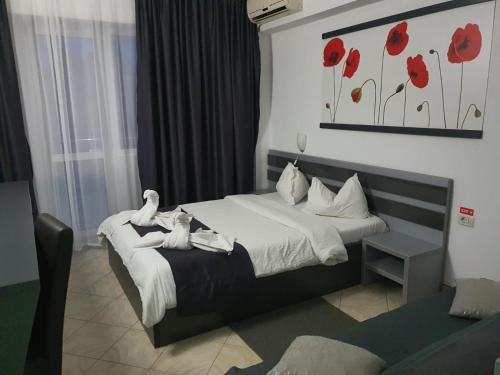 a bedroom with a bed with red flowers on the wall at Vila Blue Lagoon in Eforie Nord