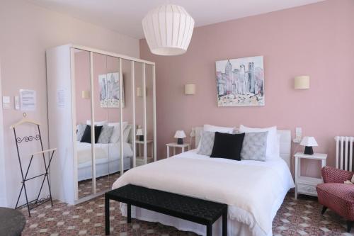 ein Schlafzimmer mit einem großen weißen Bett und einem Stuhl in der Unterkunft B&B Le Patio En Ville - Chambres d'hôtes in Narbonne
