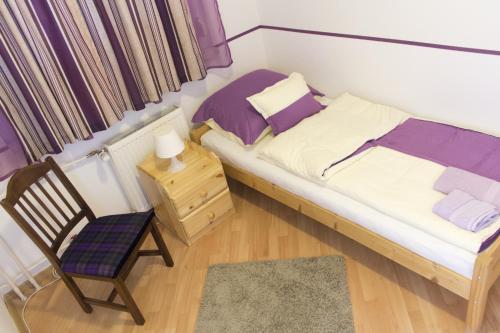 um pequeno quarto com uma cama e uma cadeira em Apartman "A" em Szeged