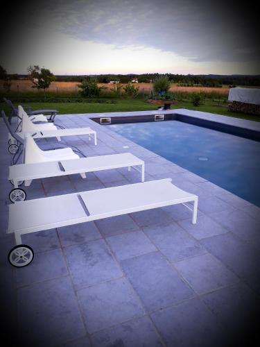 a white bench sitting next to a swimming pool at B&B chez Annie in Saint-Martin-de-Gurçon