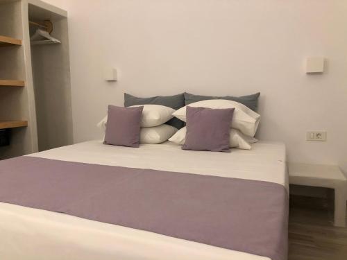 a bedroom with a bed with purple and white pillows at Selena Villa in Kamari