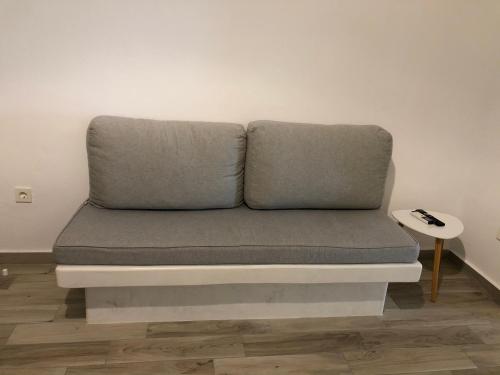 a grey couch sitting in a room with a side table at Selena Villa in Kamari