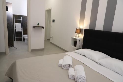 a bedroom with a bed with white towels on it at b&b Zio Luciano in Avola