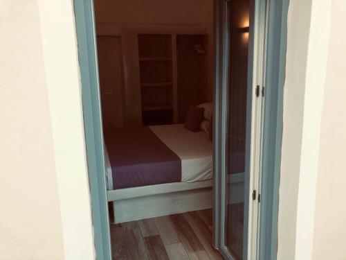 a small bedroom with a bed and a mirror at Selena Villa in Kamari