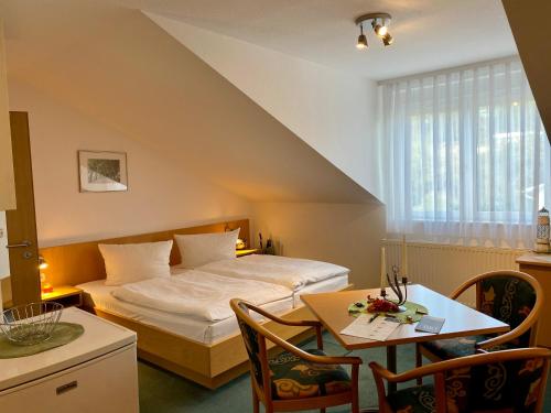 Schlafzimmer mit einem Bett, einem Tisch und Stühlen in der Unterkunft Appartementhaus Anne in Binz