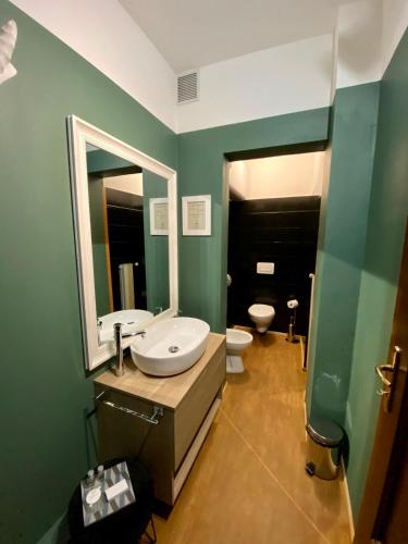 a bathroom with a sink and a mirror and a toilet at Palazzina300 in Treviso
