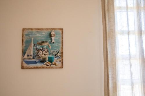 a picture of a painting of a sailboat on a wall at b&b Zio Luciano in Avola