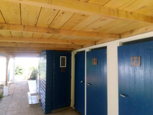 twee blauwe deuren in een kamer met een houten plafond bij Dortoire en tente individuelle in Plestin-les-Grèves