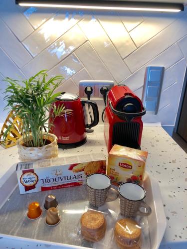 un comptoir avec une table avec des viennoiseries et une cafetière dans l'établissement Cosy Deluxe - Deauville centre, à Deauville