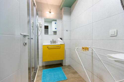 bagno con lavandino giallo e doccia di Kate Central Apartments a Ohrid