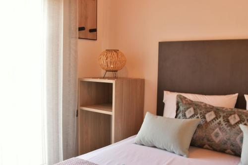 una camera con un letto e un comodino accanto a una finestra di Ktima Mimoza a Sikia