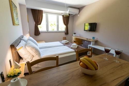 Un dormitorio con una cama y una mesa con un bol de fruta encima. en Kate Central Apartments, en Ohrid