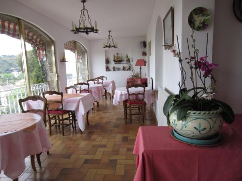 un restaurant avec des tables et des chaises et un vase fleuri dans l'établissement Hotel Belle Vue, au Lavandou