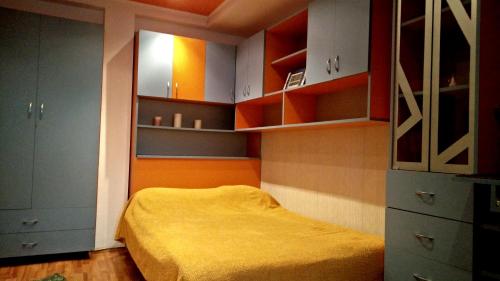 ブカレストにあるStudio French Embassyのベッドルーム(オレンジ色のベッド1台、キャビネット付)