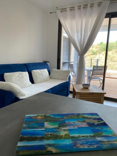 un salon avec un canapé bleu et une table dans l'établissement Stella mare à porticcio, à Porticcio