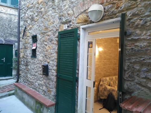 uma porta com uma persiana verde ao lado de uma parede de pedra em Casa Ida em Monte Marcello