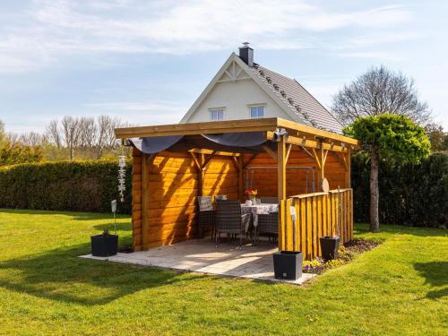 einen hölzernen Pavillon mit einem Tisch im Hof in der Unterkunft Cosy flat in Niepars with garden in Niepars