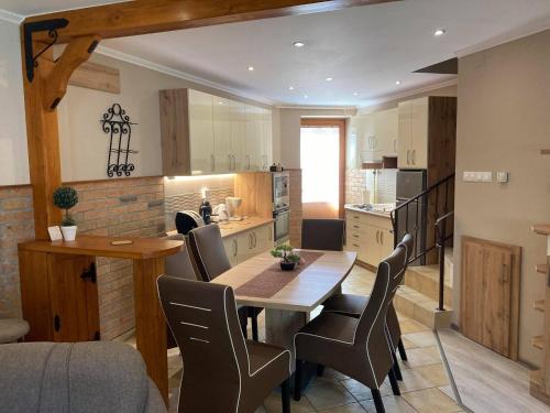 a kitchen and dining room with a table and chairs at Boróka Apartman Gyula in Gyula
