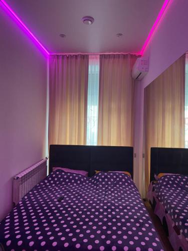 a bedroom with two beds with purple lighting at Olesi Gonhara in Dnipro