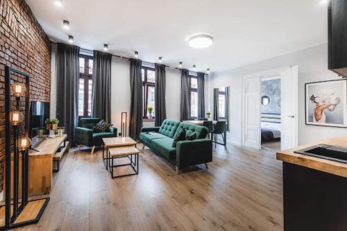 a living room with a green couch and chairs at Modern Apartments Toruń 3 in Toruń