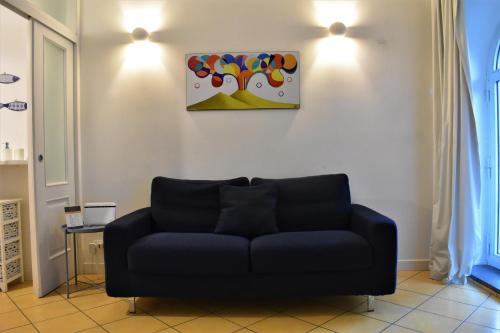 a couch in a living room with a painting on the wall at Lemon Suite in Naples