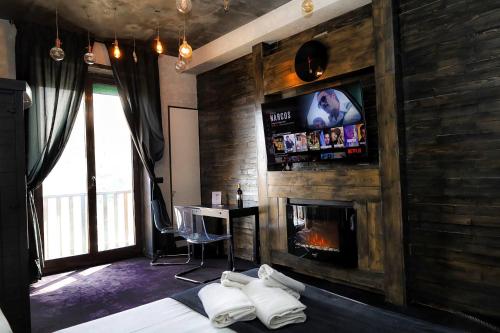 a bedroom with a fireplace and a bed and a tv at Covo Degli Angioini in Naples