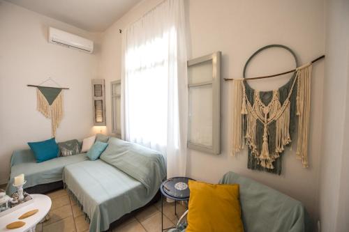 ein Wohnzimmer mit einem Sofa und einem Fenster in der Unterkunft Art apartment in Antikes Epidauros