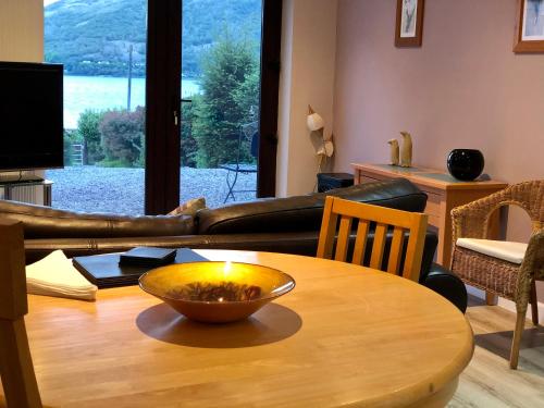 ein Wohnzimmer mit einem Tisch und einer Schüssel darauf in der Unterkunft Hunters Lodge Apartments in Ballachulish