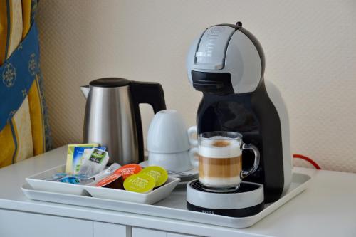 
a coffee cup and a blender on a counter at Hotel De Stern in Scheveningen
