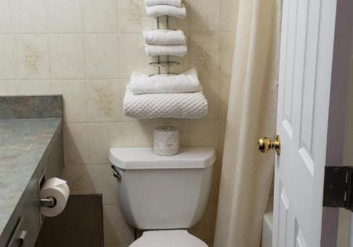 a bathroom with a pile of towels on a toilet at Elite Hotel -Downtown Center- "Ski & Northern light Tour" "Hot Spring Tour "Long-term stay" in Whitehorse