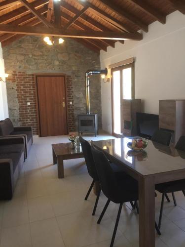 a living room with a wooden table and chairs at Love Holiday Suite 1 in Tris Elies