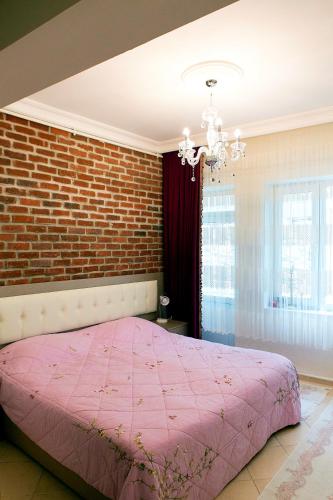 a bedroom with a pink bed and a brick wall at Best location in İstanbul in Istanbul