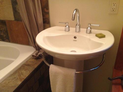 a white sink in a bathroom with a bath tub at Hyphocus Inn in Ucluelet