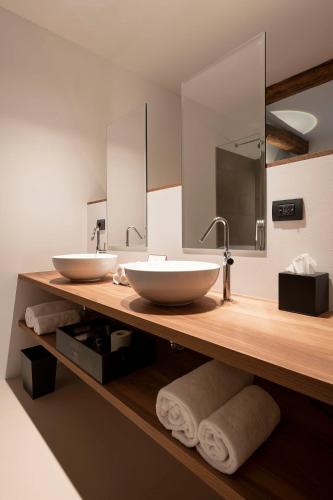 a bathroom with two sinks on a wooden counter at Castel Hörtenberg in Bolzano