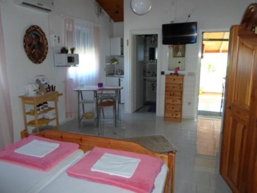a room with a bed with pink sheets and a kitchen at Studio Apartment in Nin with Terrace, Air Conditioning, Wi-Fi (233-2) in Nin
