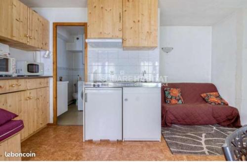eine Küche mit einem Waschbecken und einem Sofa in einem Zimmer in der Unterkunft Studio 4 personnes + parking privé in Cauterets