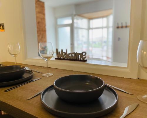 a wooden table with two glasses and a plate with bowls at New North House by Staytor Accommodation in Exeter
