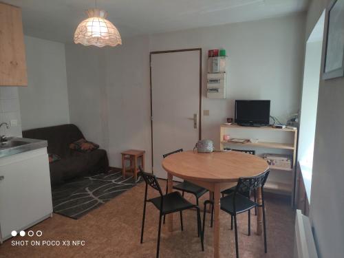 un salon avec une table et des chaises dans une pièce dans l'établissement Studio 4 personnes + parking privé, à Cauterets