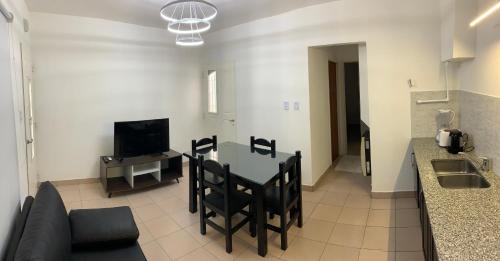 a kitchen and living room with a table and chairs at Dpto La Reina in General Roca